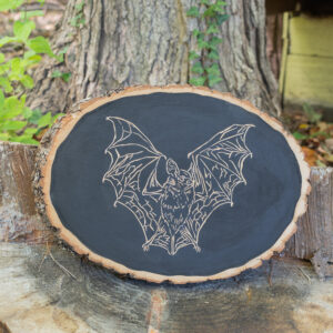 A bat with spread wings carved into wood.